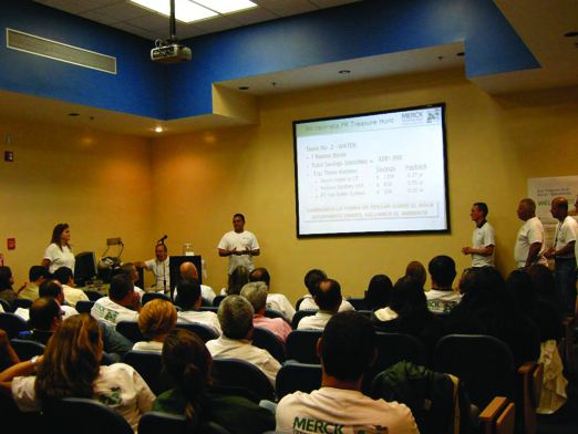 Plant staff presenting to a seated audience in a meeting room with a projection screen