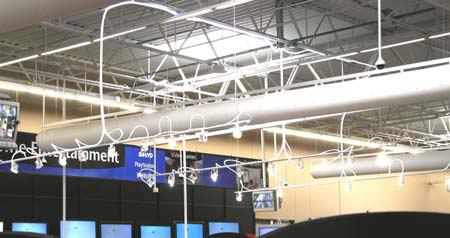 Hybrid Solar Lighting optical fiber ends fixed along a lighting track over the merchandise racks