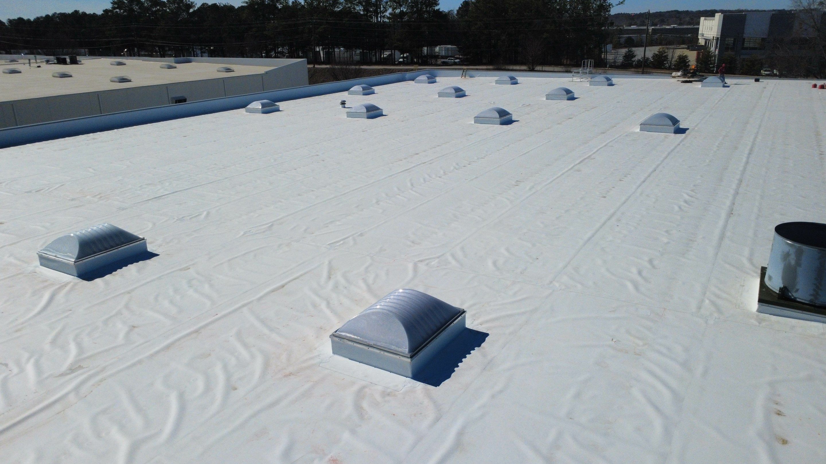 After photo - Close-up of the installed skylights and roof curbs integrated into the new high-performance TPO roofing system
