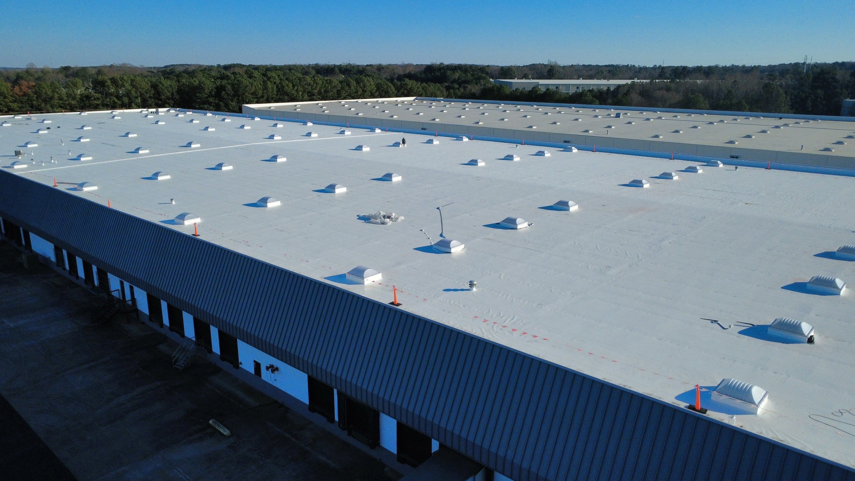 After photo - Wide aerial view of the completed 290,000 SF white TPO roof with new Sunoptics curb-mount skylights